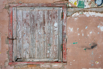 Fototapeta na wymiar View of the old wooden window over deteriorated wall