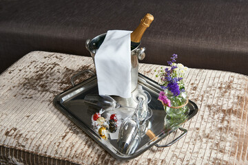 Tray with a bottle of champagne in a champagne bucket with ice,