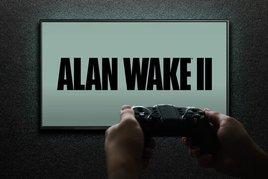Alan Wake 2 game on TV screen with gamepad in hand on black textured wall with light. Astana, Kazakhstan - November 13, 2023.