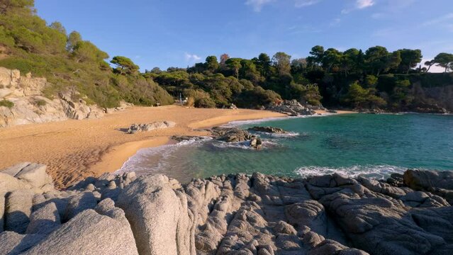 Impressive virgin beach with turquoise blue sea, green vegetation without people, gold sand Lloret De Mar on the Costa Brava of Girona, calm image. Relaxation and copy space