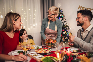 Happy multi-generation family enjoying in a lunch together at home. Family on Christmas dinner at...
