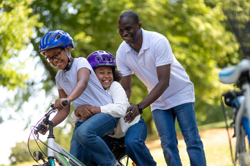 Cute african american kids riding bikes in the park