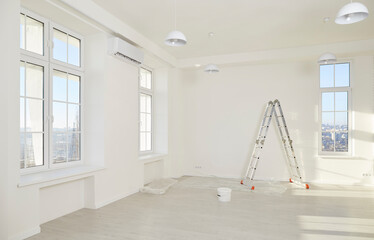 Interior of big newly renovated apartment for rent or relocation. Spacious room with ladder, paint...