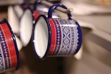 Foto op Plexiglas Selective focus of colorful enameled mugs hanging on holders © Wirestock