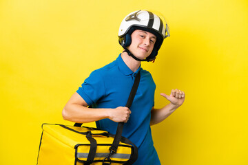 Young Brazilian man with thermal backpack isolated on yellow background proud and self-satisfied