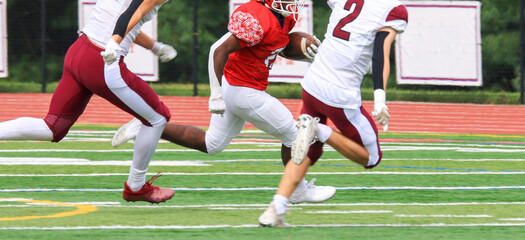 Fototapeta premium Football running back running away from defenders during a game