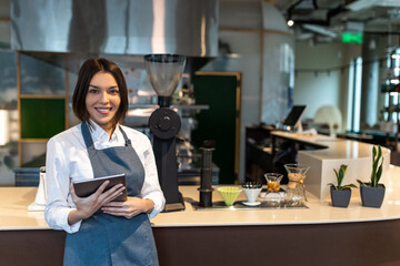 Short-haired pretty girl in apron in a coffee shop