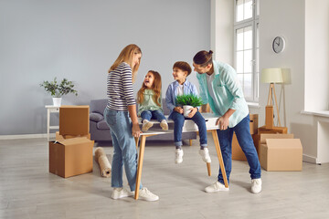 Happy family couple with two kids boy and girl on moving day smiling in a new apartment with unpacked boxes on background. Home owners enjoying buying flat. Relocating, real estate, mortgage concept. - obrazy, fototapety, plakaty