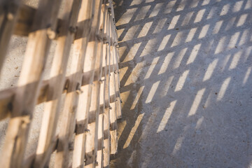 The wooden frame of an Asian yurt casts a shadow on the ground - obrazy, fototapety, plakaty