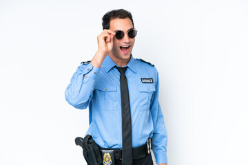 Young police caucasian man isolated on white background with glasses and surprised