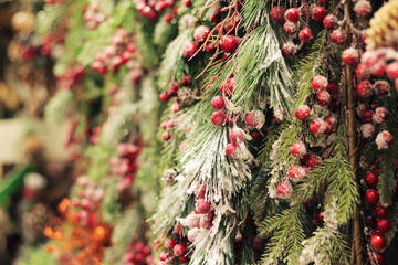 Artificial Christmas tree branches with clusters of red berries, artificial snow. New Year's decor....