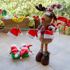 Toy Rudolph reindeer hanging  Santa hats on clothesline