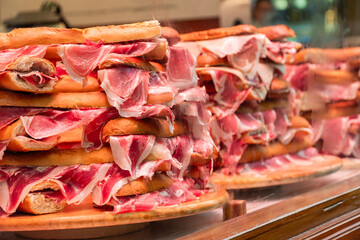 A stack of Serrano ham sandwiches, in the store window. 