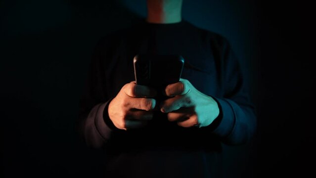 4K Video close up of anonymous hands texting on mobile phone screen in the dark tone during the night.