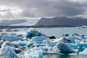 Ice floes in a glacial lake in Iceland with vulcano mountains in the background, the climate crisis in northern Europe, glacial melting, beautiful landsacpe