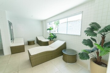 Room in white colors for a relaxation area with beds and plants