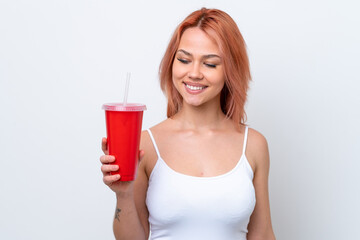 Young Russian woman holding soft drink isolated on white background with happy expression