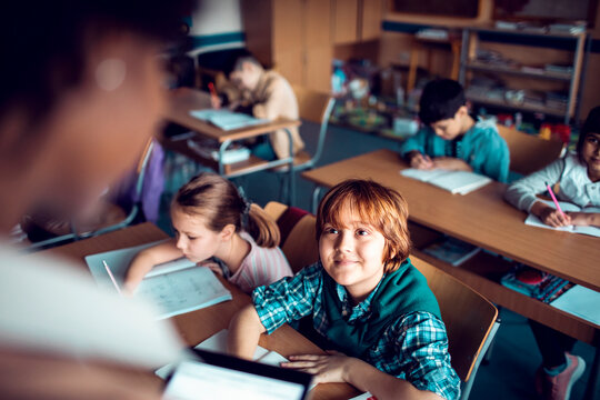 Young boy looking at teacher in elementary classroom