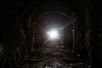 Dark underground tunnel. Light at the end of tunnel