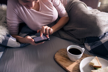 Breakfast in Bed with Smartphone and Coffee