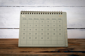 MAY 2024 cardboard desk calendar and planner on a wooden texture table