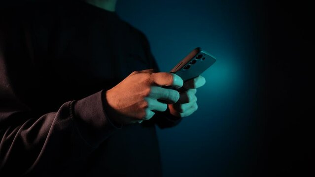 4K Video side shot close up of anonymous hands texting on mobile phone screen in the dark tone during the night.