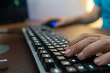 Close up man hand typing keyboard on desktop in darkness operating room, cyber security concept....
