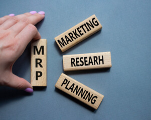 MRP - Marketing Research Planning symbol. Concept word MRP on wooden cubes. Businessman hand. Beautiful grey background. Business and MRP concept. Copy space.