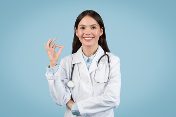 Happy young female doctor showing OK sign with hand