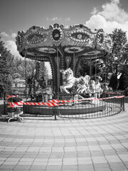 In the amusement park, the carousels do not operate; they are fenced off with warning tape.  There...