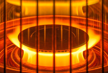 Close-up on a burning gas burner with its bright yellow flame dancing gracefully in circle behind a...