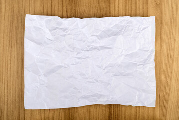 Top view of a crumpled piece of white office paper on a white background.