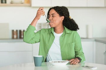 Black woman starts day with tasty breakfast in modern kitchen