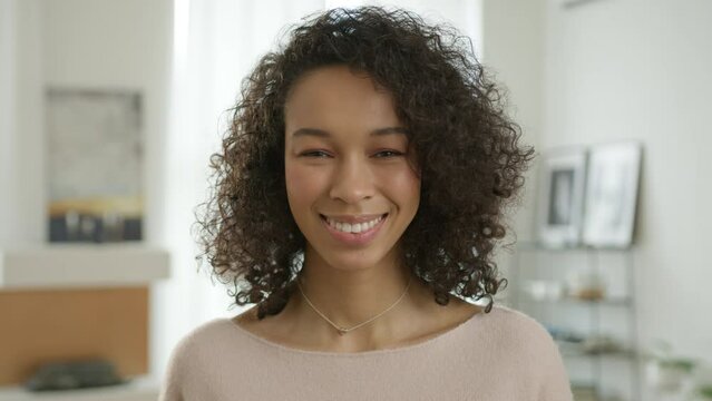 Attractive Multi Ethnical Woman Smiling On Motion Background 4K. Portrait Cheerful Smiling Face Multi Racial Woman Looking At Camera. Positive Female Diverse Model With Curly Hair, Confident Lifestyle