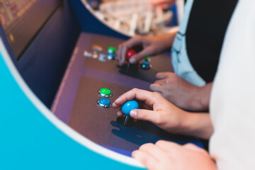 Kids play slot machine at amusement theme park, children play arcade gaming machine, racing and...