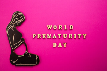 World Prematurity day concept. Banner with the inscription in wooden letters and pregnant woman.