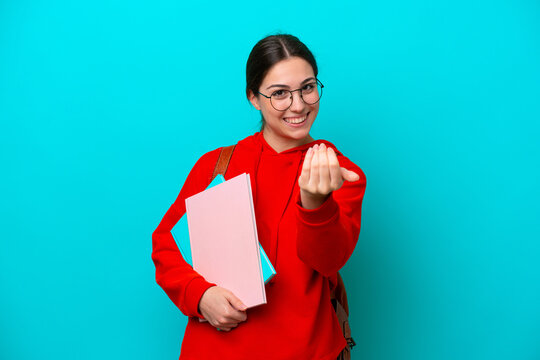 Young student caucasian woman isolated on blue background inviting to come with hand. Happy that you came