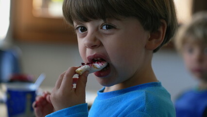 Close-Up Candid Moment - Child Relishing Morning Brioche with Jelly Spread