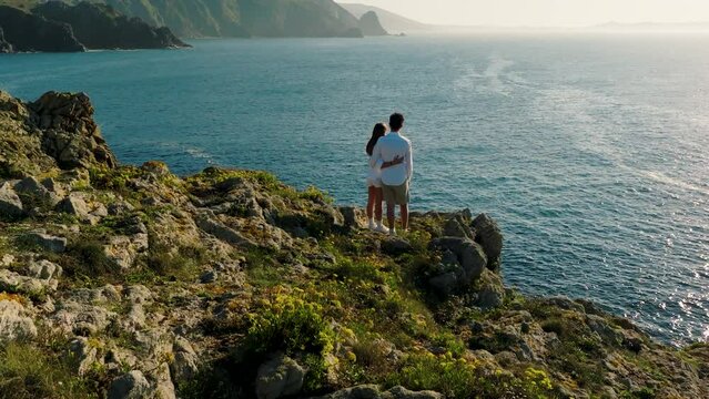 Lovely Couple Admiring Stunning Sea View From Steep Rocky Cliff In Ferrol, Galicia, Spain. aerial