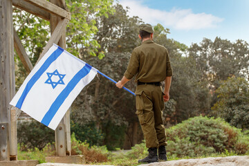 A guy in a soldier's uniform with an Israeli flag