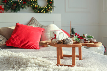 Wooden tray with breakfast on the bed