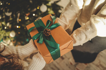 Gift box in the hands of mother and daughter, Christmas mood