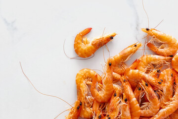 Raw prawn shrimps on white marble background with copy space top view