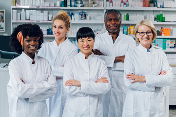 An interracial group of pharmacists is confidently standing in the pharmacy.