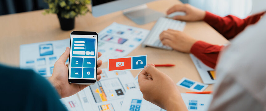 Panorama banner of startup UX developer or company employee design user interface or UI prototype for mobile application or website software with software display on smartphone in office. Synergic