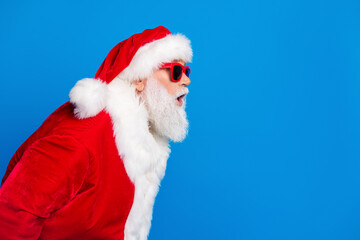 Photo portrait of retired old man astonished reaction dressed stylish santa claus costume coat isolated on blue color background