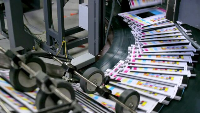 Flyers, newspapers, leaflets on the conveyor belt in a printing house