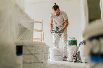 A house painter is mixing materials for plasterwork and renovating house.