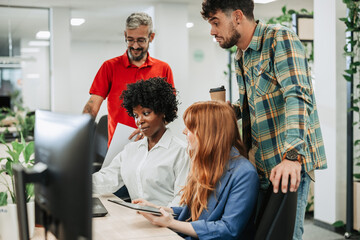 Obraz premium Multiracial colleagues working together and using laptop in the office