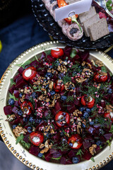 Wonderful delicious salad with avocado, beetroot, cherry tomatoes and fresh blueberries, herbs.